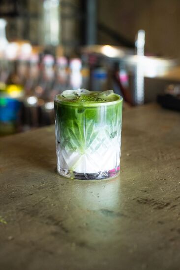 An iced matcha drink in chunky rock glass